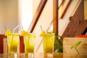 a group of three glasses of orange juice on a table at Fort Bridge View in Cochin