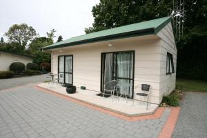 a small shed with chairs and a table in it at Oamaru TOP 10 Holiday Park in Oamaru