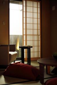 京都市にあるNo.10 京都ハウスの椅子とテーブル、窓が備わる客室です。