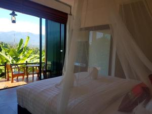 a bedroom with a bed and a balcony with a view at Chang Pai Hill in Pai