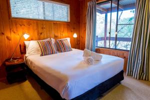 a bedroom with a large white bed with a window at Granite Belt Retreat and Brewery in Stanthorpe