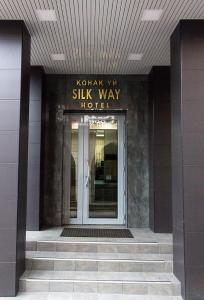 a building with a glass door with a sign on it at Silk Way in Almaty