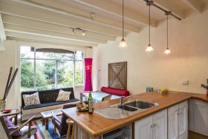 a kitchen with a sink and a living room with a couch at Salty Dog by the Sea - Pet Friendly in Rye