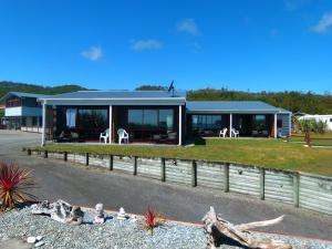 uma casa com uma cerca em frente em BeachView Motel em Greymouth