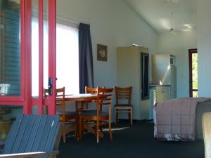 a room with a table and chairs and a kitchen at BeachView Motel in Greymouth