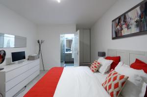 ein Schlafzimmer mit einem weißen Bett mit roten und weißen Kissen in der Unterkunft Red-line in Serris