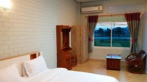een slaapkamer met een bed en een raam bij Three Bays Resort in Prachuap Khiri Khan