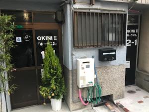 a pay phone on the side of a building at Guest House OkiniⅡ in Osaka