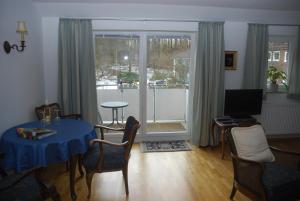 a living room with a blue table and chairs at Ferienwohnung Grünes Herz in Kiel +6 photos
