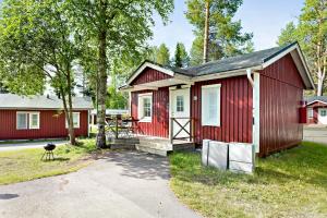 a red tiny house with a pathway leading to it at First Camp Arcus-Luleå in Luleå