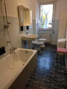 een badkamer met 2 toiletten, een bad en een wastafel bij Nuovo appartamento a Clusone in Clusone