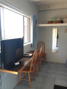a living room with a tv and a chair at Beach Drive Motel in Batemans Bay
