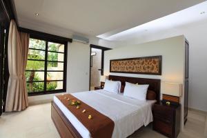 - une chambre avec un grand lit et une grande fenêtre dans l'établissement Villa Baruna, à Banjar