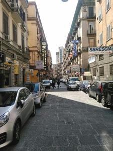 uma movimentada rua da cidade com carros estacionados na rua em B&B da Ary Colorful Rooms em Nápoles