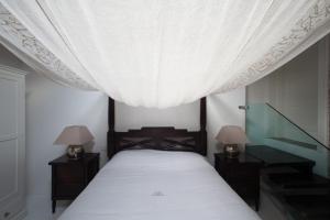 フェラーラにあるHorti Della Fasanaraのベッドルーム1室(天蓋付きベッド1台、ランプ2つ付)