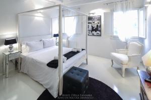 フェラーラにあるHorti Della Fasanaraの白いベッドルーム(ベッド1台、椅子付)