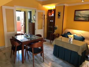 1 dormitorio y sala de estar con mesa de comedor. en Casa Bahía de Cádiz, en Puerto Real