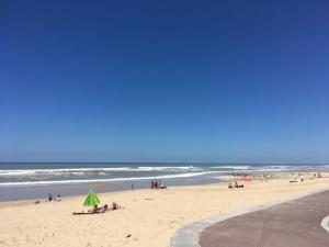 um grupo de pessoas numa praia perto do oceano em La maison d'été de mes parents em Vendays-Montalivet