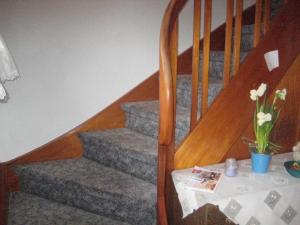 una escalera con un jarrón de flores y una mesa en Haus Peters, en Büsum