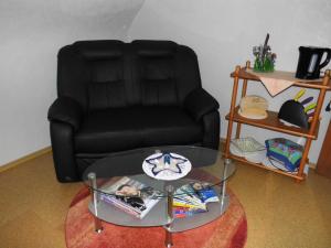 ビューズムにあるHaus Petersの黒い椅子、ガラスのコーヒーテーブル、ガラスのコーヒーテーブル