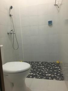 a bathroom with a toilet and a shower at Repag Wayan Canggu Hostel in Canggu