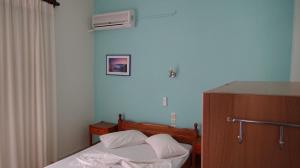 a small bedroom with a bed and a fan at Poros House Hotel in Poros