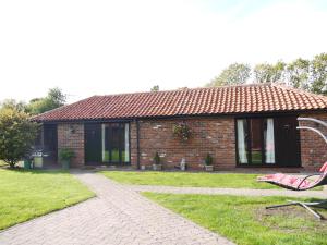 a brick house with a chair in front of it at Barn Owl Lodge in Lowestoft