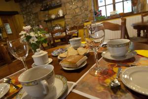 a table with cups and plates and glasses on it at La Lobera in Las Rozas de Valdearroyo