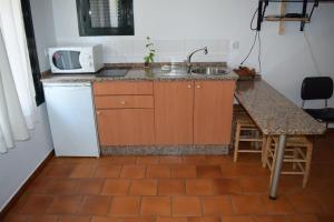 a small kitchen with a sink and a microwave at Casa Rural Los Pinos in Hinojos