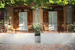 a balcony of a building with chairs and tables at Sala Prabang Hotel in Luang Prabang
