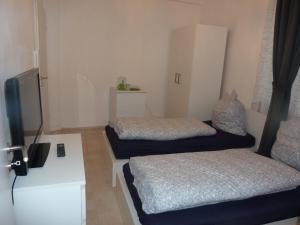 a room with two beds and a tv in it at Relax in Offenbach