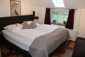 a large bed with white sheets and pillows in a bedroom at Zum alten Krug in Wangerland