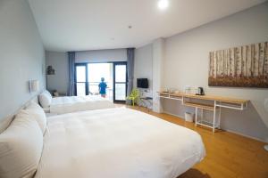 ein Hotelzimmer mit 2 Betten und einem Tisch in der Unterkunft Xi Tou in Sunny Day Inn in Lugu
