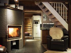 sala de estar con chimenea y escalera en Inari Juutua, en Inari