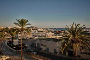 a harbor with palm trees and a marina with boats at Sir Joan Hotel, part of Sircle Collection in Ibiza Town