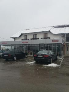 twee auto's geparkeerd op een parkeerplaats voor een winkel bij Motel Restoran Gurman in Banja Luka