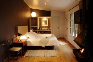 a bedroom with a large white bed and a television at Can Barrina in Montseny