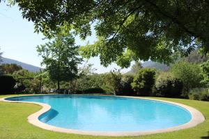 una piscina azul en un patio con árboles en Can Barrina en Montseny