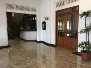 un hall avec une porte en bois et des plantes en pot dans l'établissement Shalimar Hotel, à Colombo