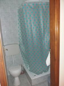 a bathroom with a toilet and a shower curtain at Motel Restoran Gurman in Banja Luka