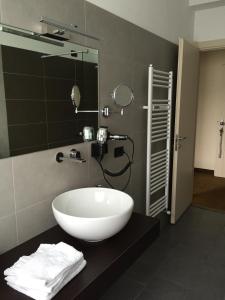 a bathroom with a large white sink and a mirror at Hotel Lido in Angera