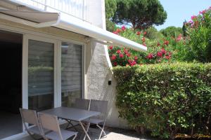 a table and chairs on a patio with flowers at Le flamant - Appartement P2 de 40m2 grande terrasse-parking-wifi in La Grande-Motte