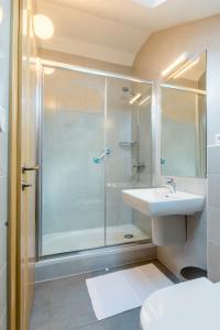a bathroom with a glass shower and a sink at Vila Mimoza in Milna