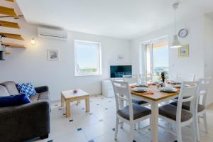 ein Esszimmer und ein Wohnzimmer mit Tisch und Stühlen in der Unterkunft Vila Mimoza in Milna