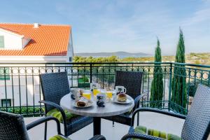 einen Tisch mit Speisen und Getränken auf dem Balkon in der Unterkunft Vila Mimoza in Milna