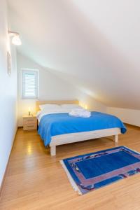 ein Schlafzimmer mit einem Bett mit blauer Bettwäsche und einem blauen Teppich in der Unterkunft Vila Mimoza in Milna + 33 Fotos