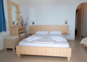 a bedroom with a wooden bed with towels on it at Villa Meltemi in Iraklia