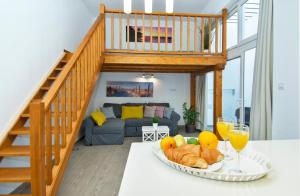 a room with a table with a bowl of fruit and a staircase at FAMARA. MAREA in Famara