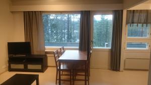 a dining room with a table and chairs and a window at Kotipaljakka in Kotila