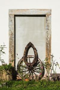 une roue assise dans l'herbe devant un garage dans l'établissement Winnica Agat, à Świerzawa
